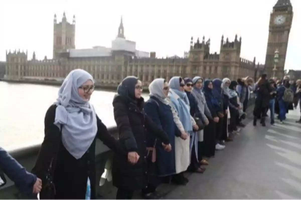 Women wearing hijabs holding hands to form a human chain on a bridge in London with Parliament and Big Ben in the background Women wearing hijabs holding hands to form a human chain on a bridge in London with Parliament and Big Ben in the background