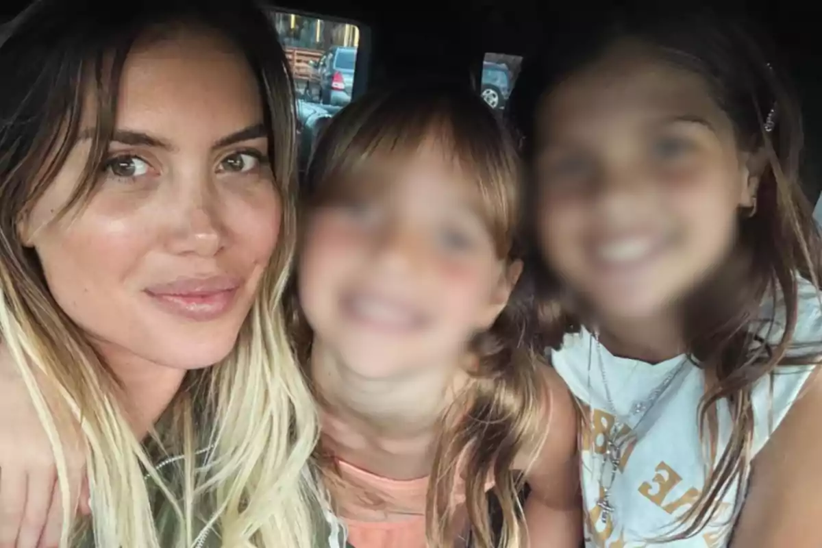 A woman smiles next to two girls with blurred faces inside a car. A woman smiles next to two girls with blurred faces inside a car.