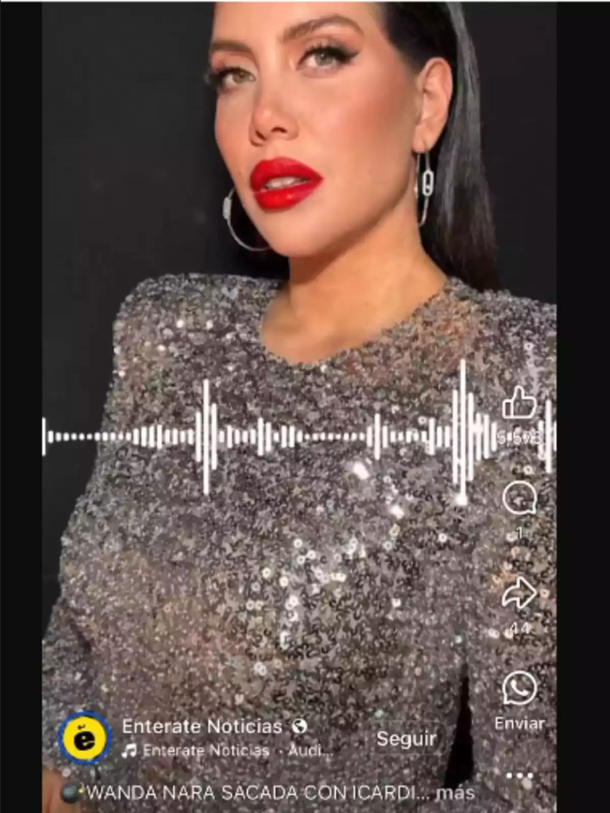 Mujer de cabello oscuro y labios rojos usando un vestido brillante de lentejuelas plateadas frente a un fondo negro