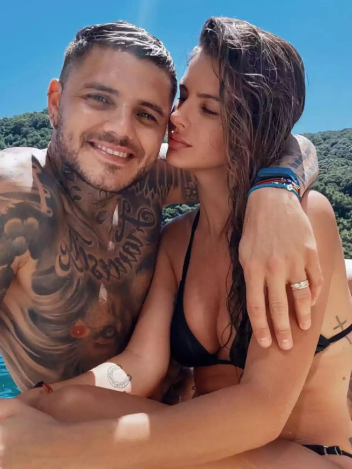 Couple hugging in swimsuits enjoying a sunny day outdoors with a background of greenery and blue sky Couple hugging in swimsuits enjoying a sunny day outdoors with a background of greenery and blue sky