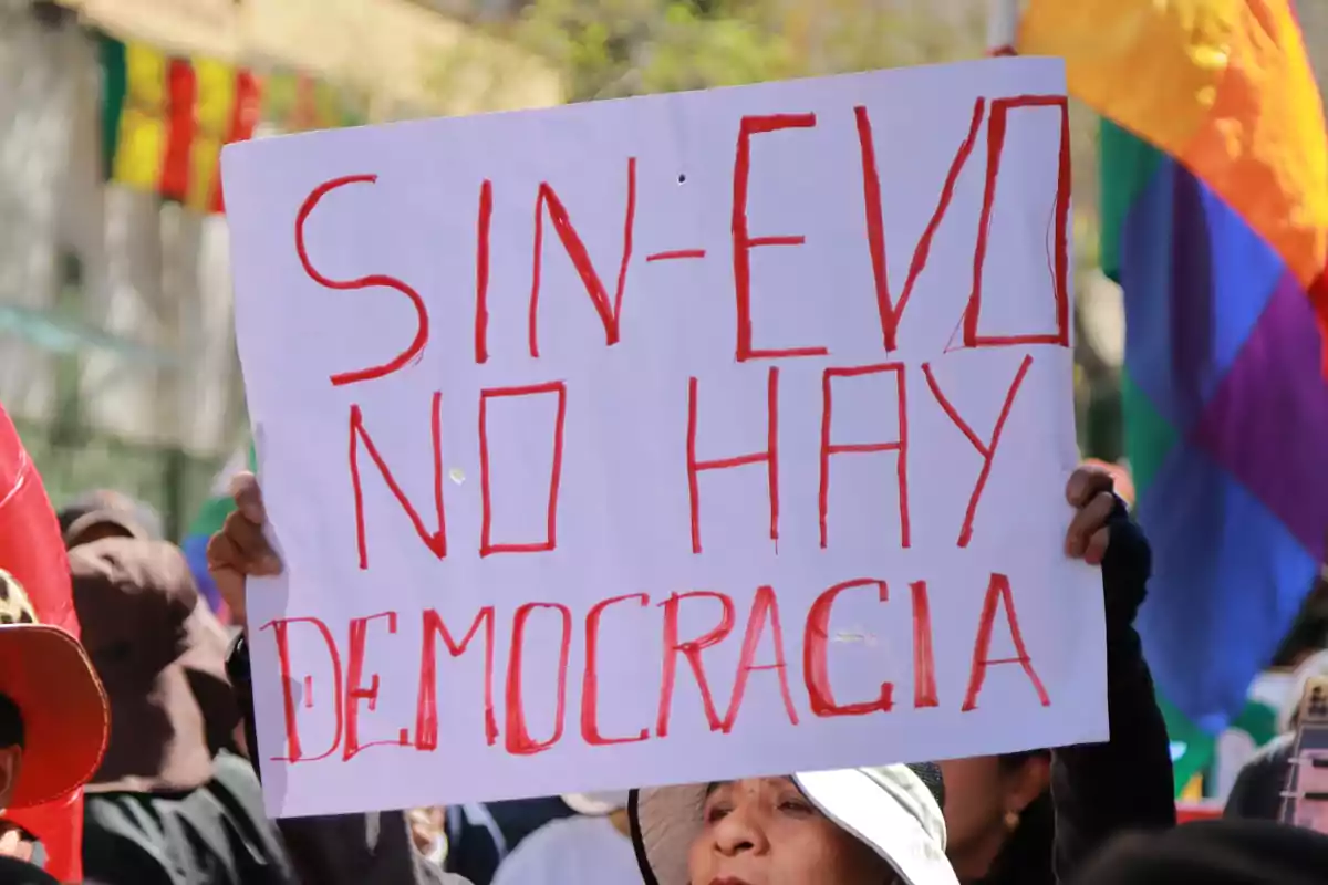 Persona sostiene un cartel escrito a mano que dice 