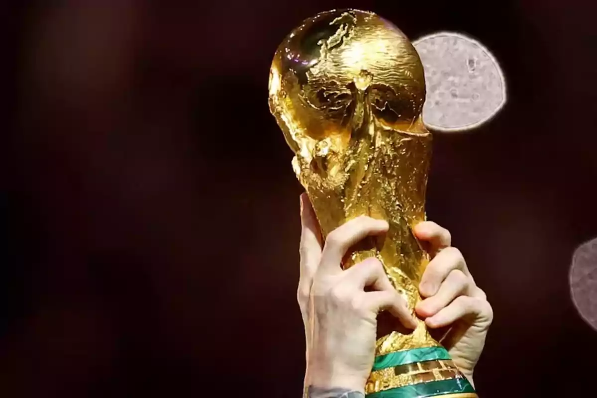 Hands raising the golden FIFA World Cup trophy
