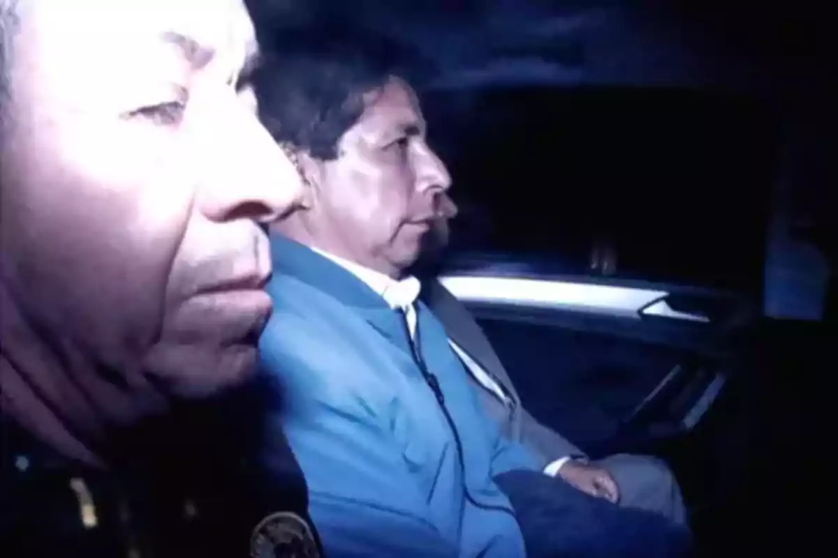 Dos hombres sentados en el asiento trasero de un automóvil en un ambiente oscuro Dos hombres sentados en el asiento trasero de un automóvil en un ambiente oscuro