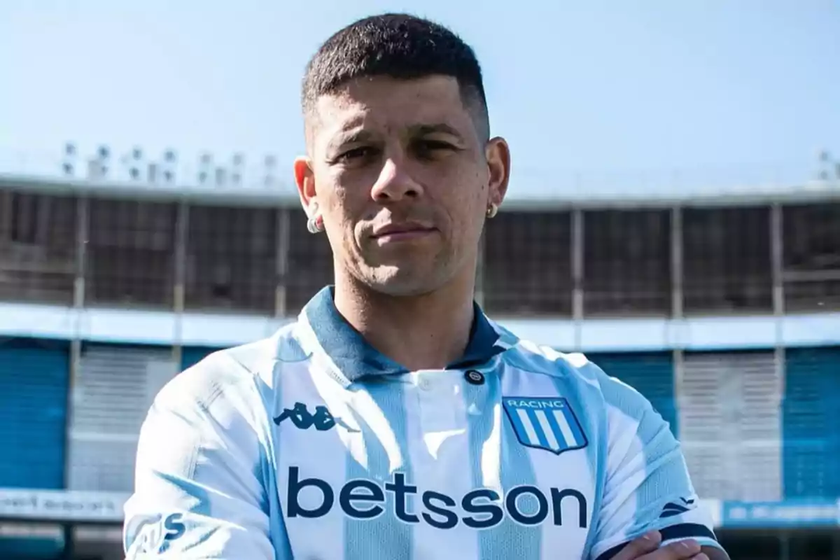 Futbolista con camiseta de Racing Club posando en un estadio