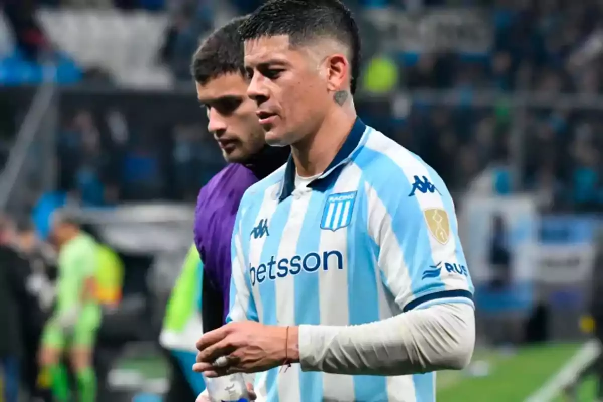 Jugador de fútbol con camiseta de Racing Club caminando en el campo de juego durante un partido Jugador de fútbol con camiseta de Racing Club caminando en el campo de juego durante un partido