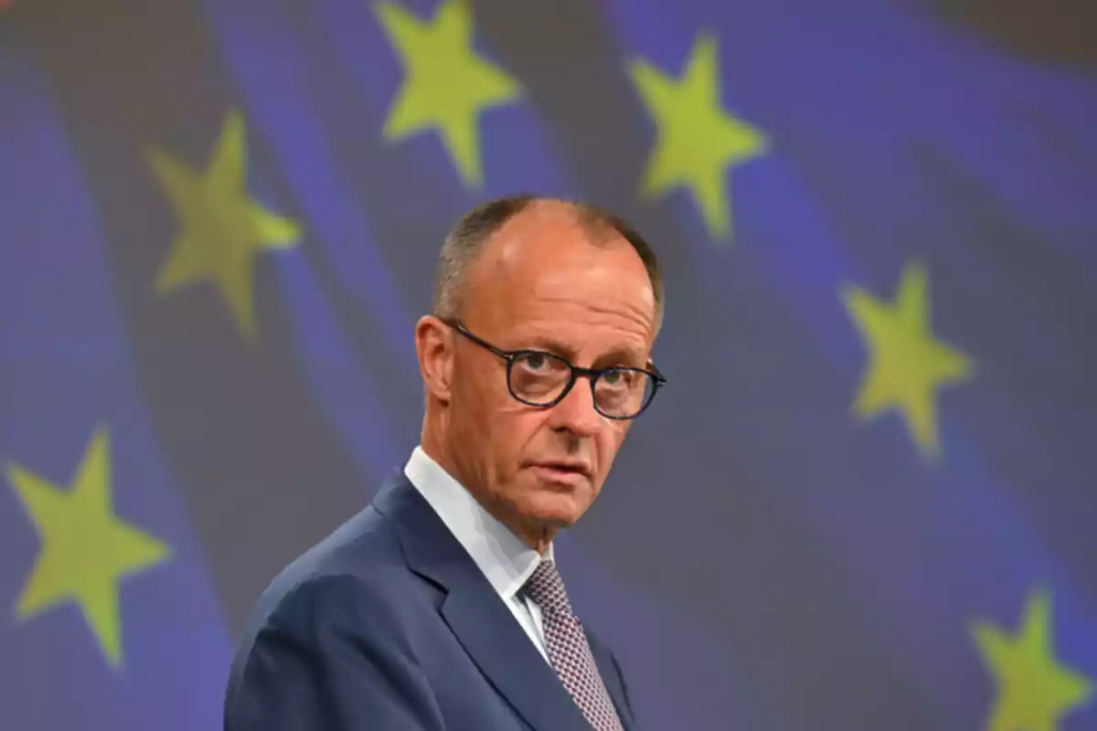 Man in a suit and glasses in front of a background with yellow stars on blue Man in a suit and glasses in front of a background with yellow stars on blue