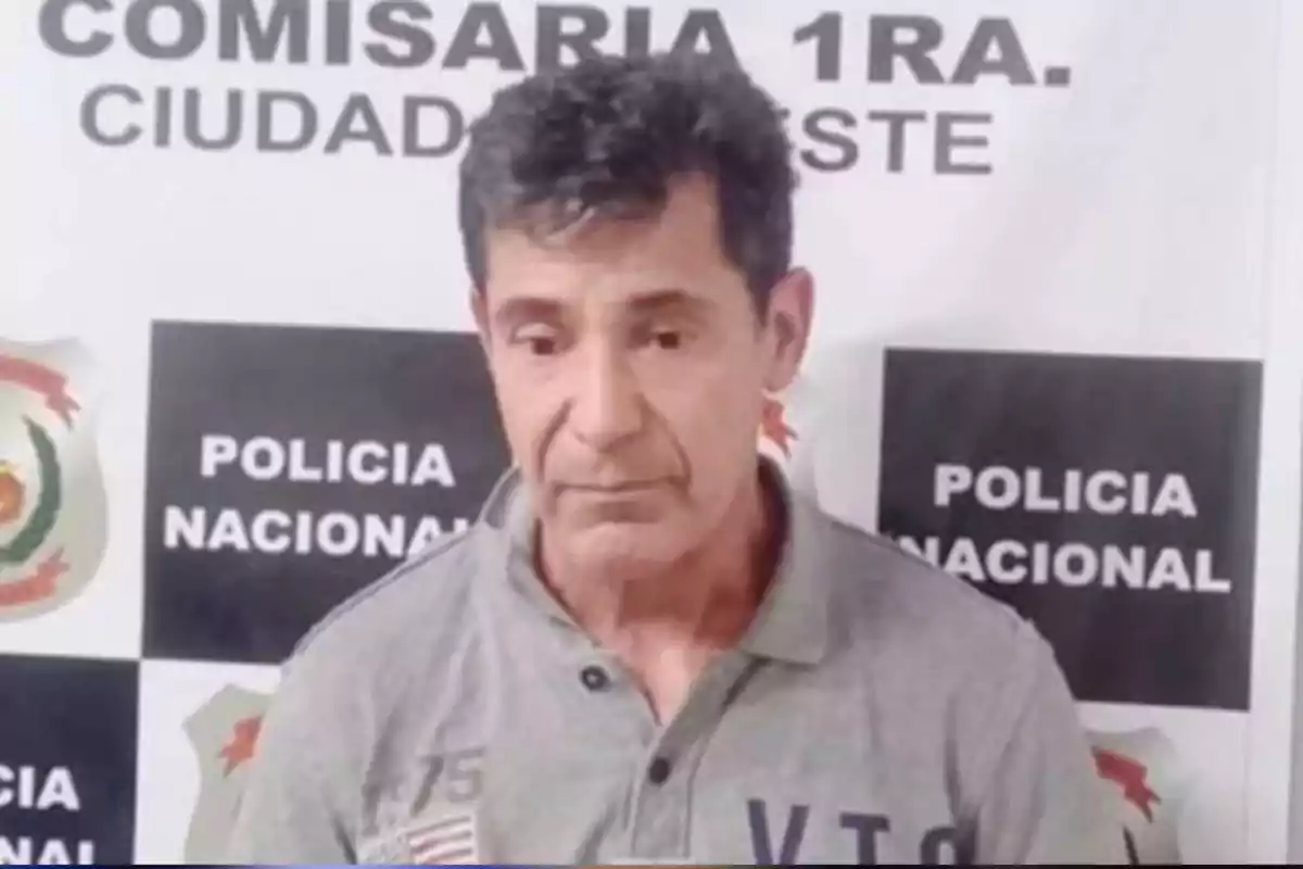 Dark-haired man with a serious expression posing in front of a national police sign at a police station Dark-haired man with a serious expression posing in front of a national police sign at a police station