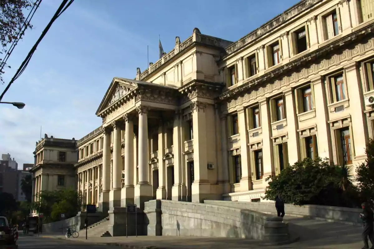 Facade of an old building with classical architecture, columns, and staircases in a city