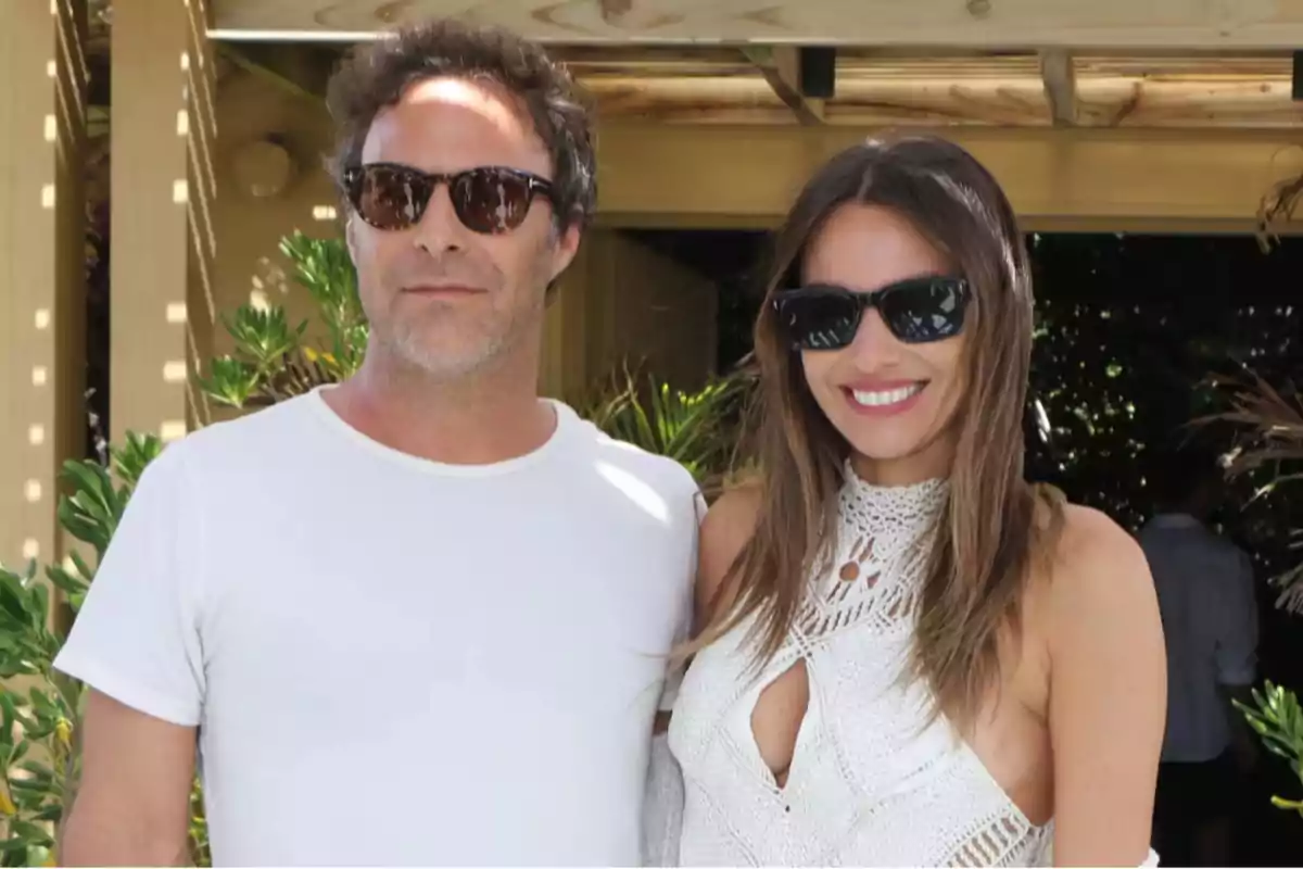 Pareja posando al aire libre con gafas de sol y ropa veraniega