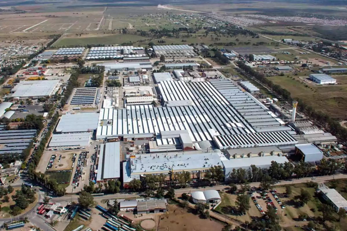 Vista aérea de un gran complejo industrial rodeado de áreas verdes y caminos