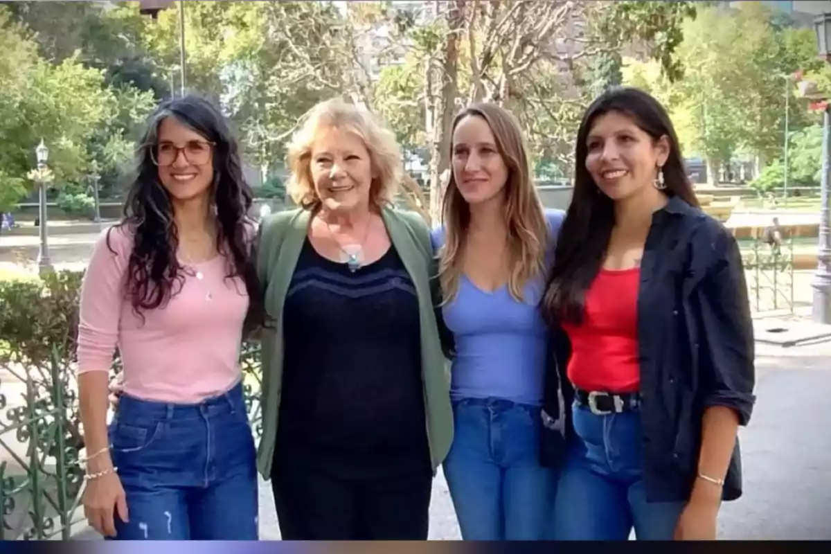 Cuatro mujeres sonríen y posan juntas al aire libre en un parque con árboles y luz natural. Cuatro mujeres sonríen y posan juntas al aire libre en un parque con árboles y luz natural.