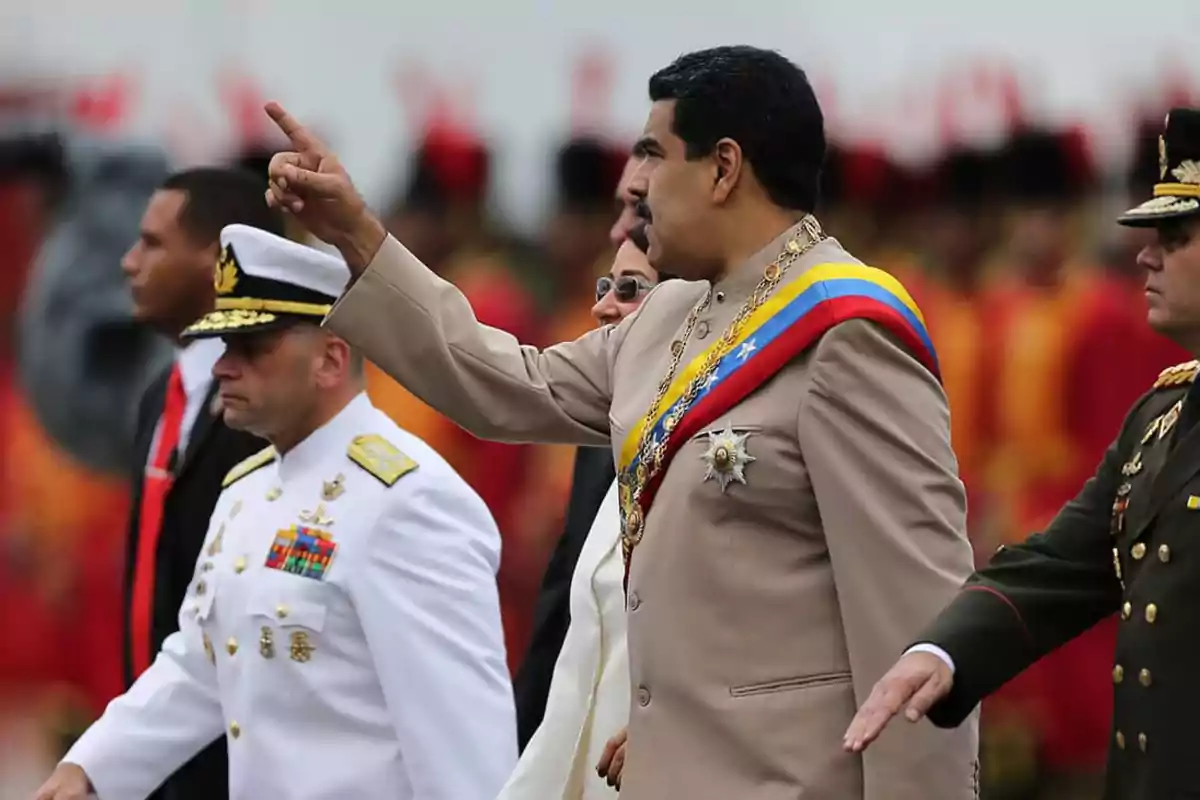Un hombre con banda presidencial y uniforme beige camina junto a oficiales militares durante un evento oficial Un hombre con banda presidencial y uniforme beige camina junto a oficiales militares durante un evento oficial