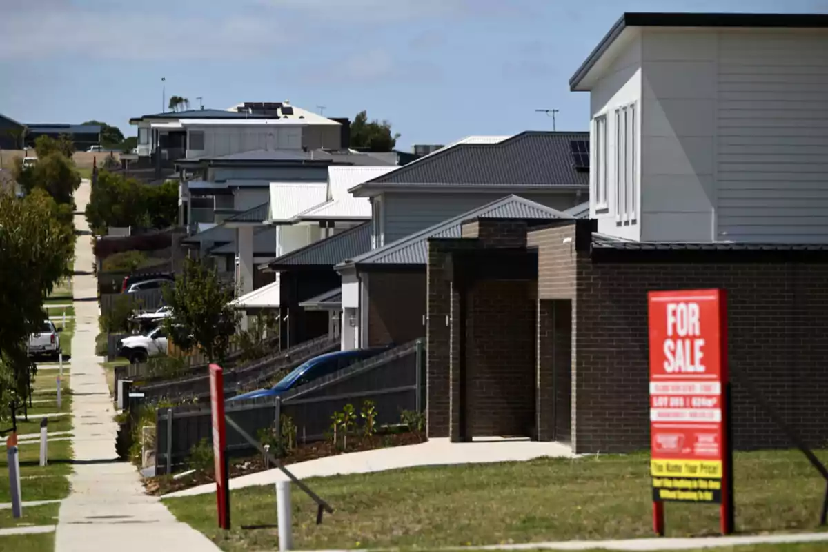 Row of modern houses in a residential area with a for sale sign in the foreground Row of modern houses in a residential area with a for sale sign in the foreground