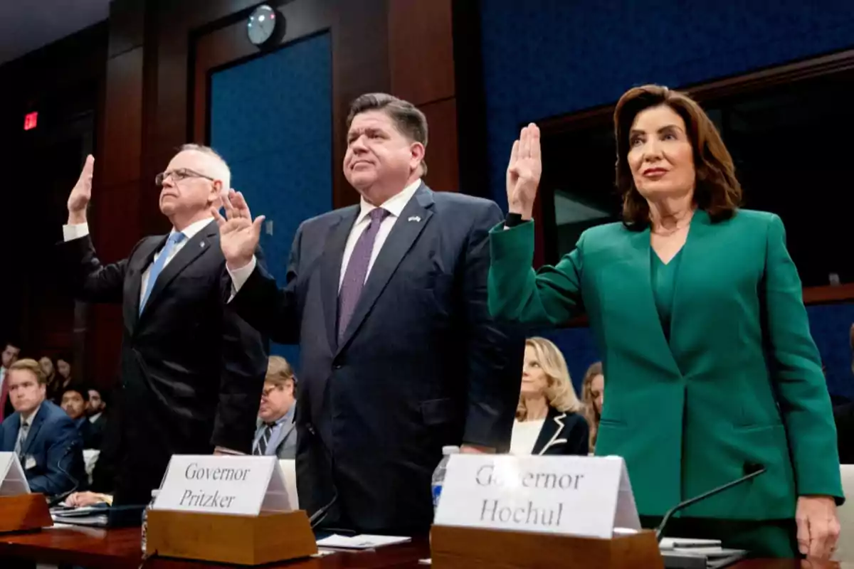 Three people standing with their right hand raised in an oath gesture during a hearing in an official chamber Three people standing with their right hand raised in an oath gesture during a hearing in an official chamber