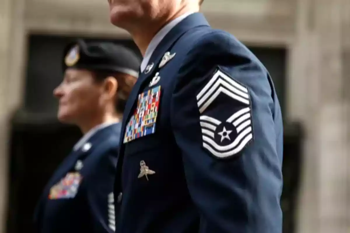 Dos personas con uniforme militar azul marino con insignias y medallas