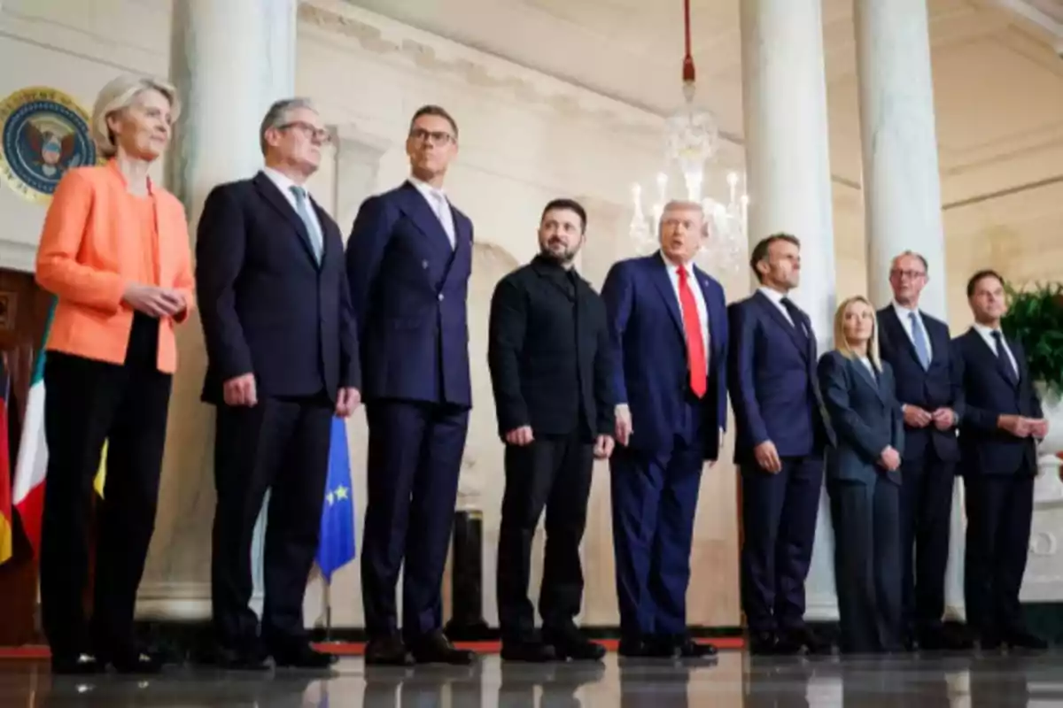Grupo de líderes mundiales posando juntos en un salón elegante con columnas y banderas al fondo