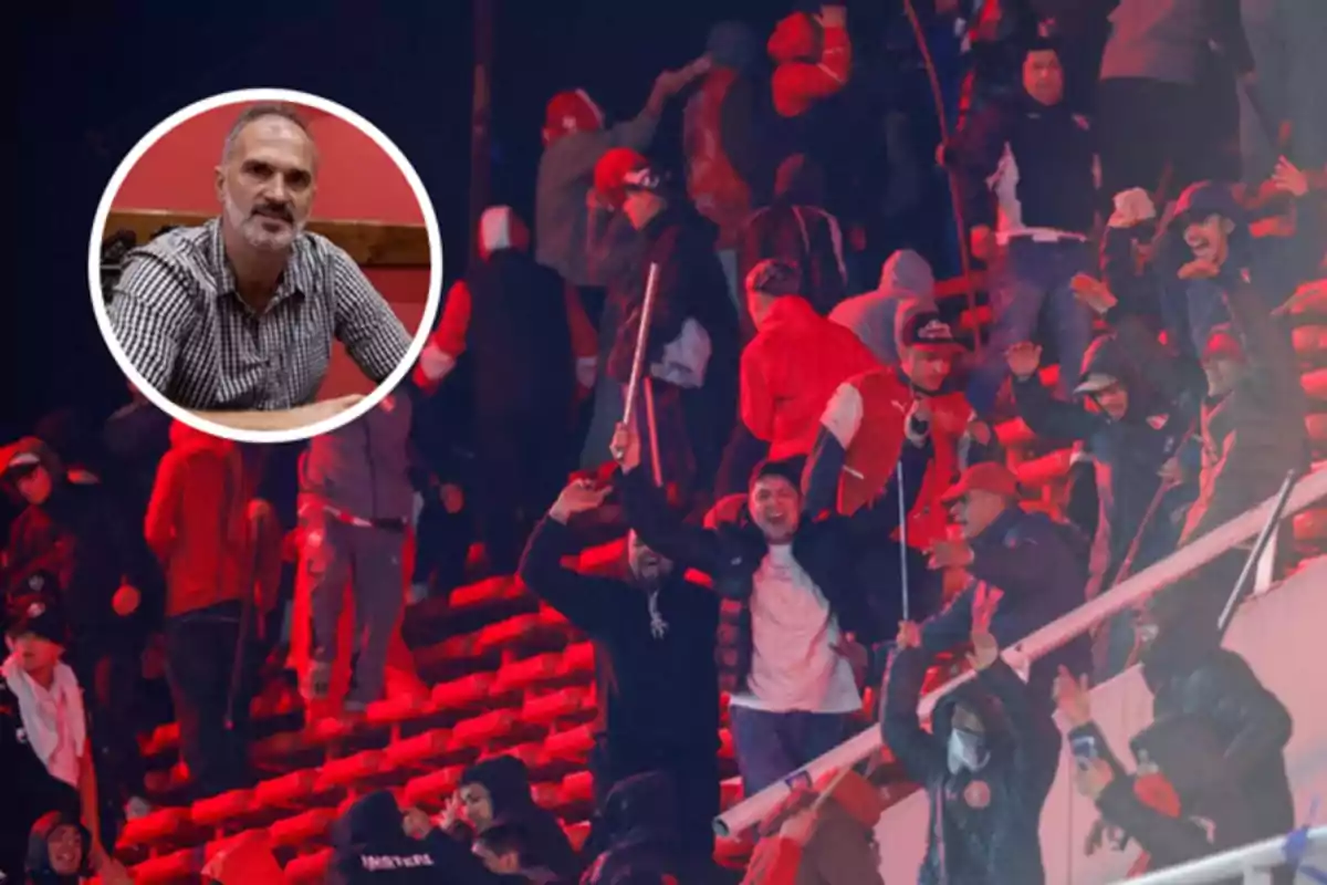Fans in the stands of a stadium during a riot with red lighting, and an inset shows a gray-haired, bearded man sitting in front of a red wall.