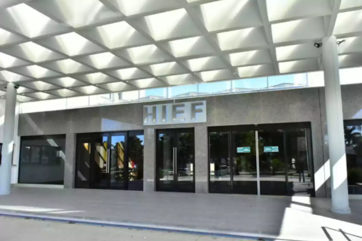 Main entrance of a modern building with the sign HIEF above the door and a geometrically designed ceiling Main entrance of a modern building with the sign HIEF above the door and a geometrically designed ceiling