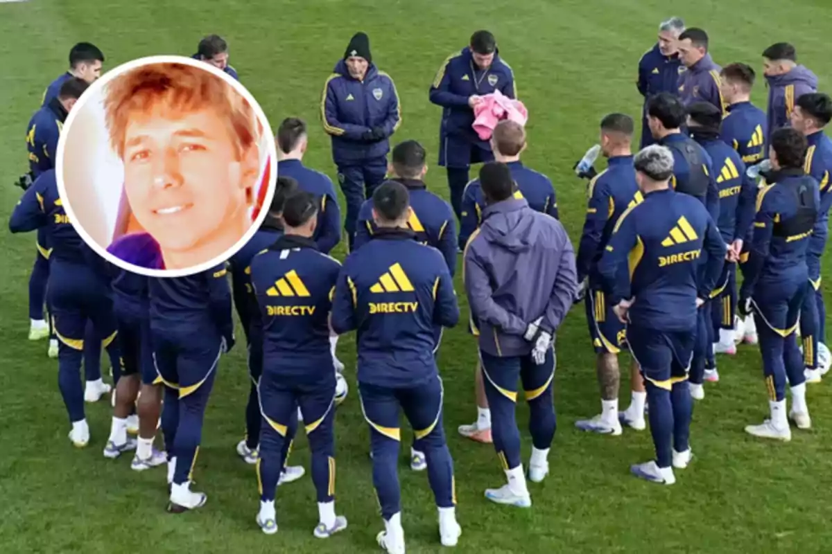 A group of players in blue and yellow uniforms is gathered in a circle on a grass field while a man in the center holds a pink garment, and in the upper left corner there is a box with the face of a smiling young man.