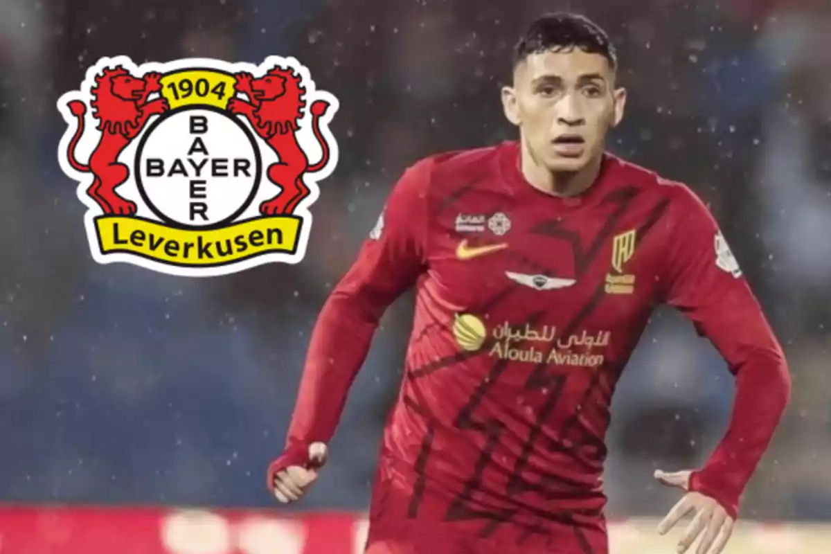 Futbolista con uniforme rojo en acción y el escudo del Bayer Leverkusen al fondo