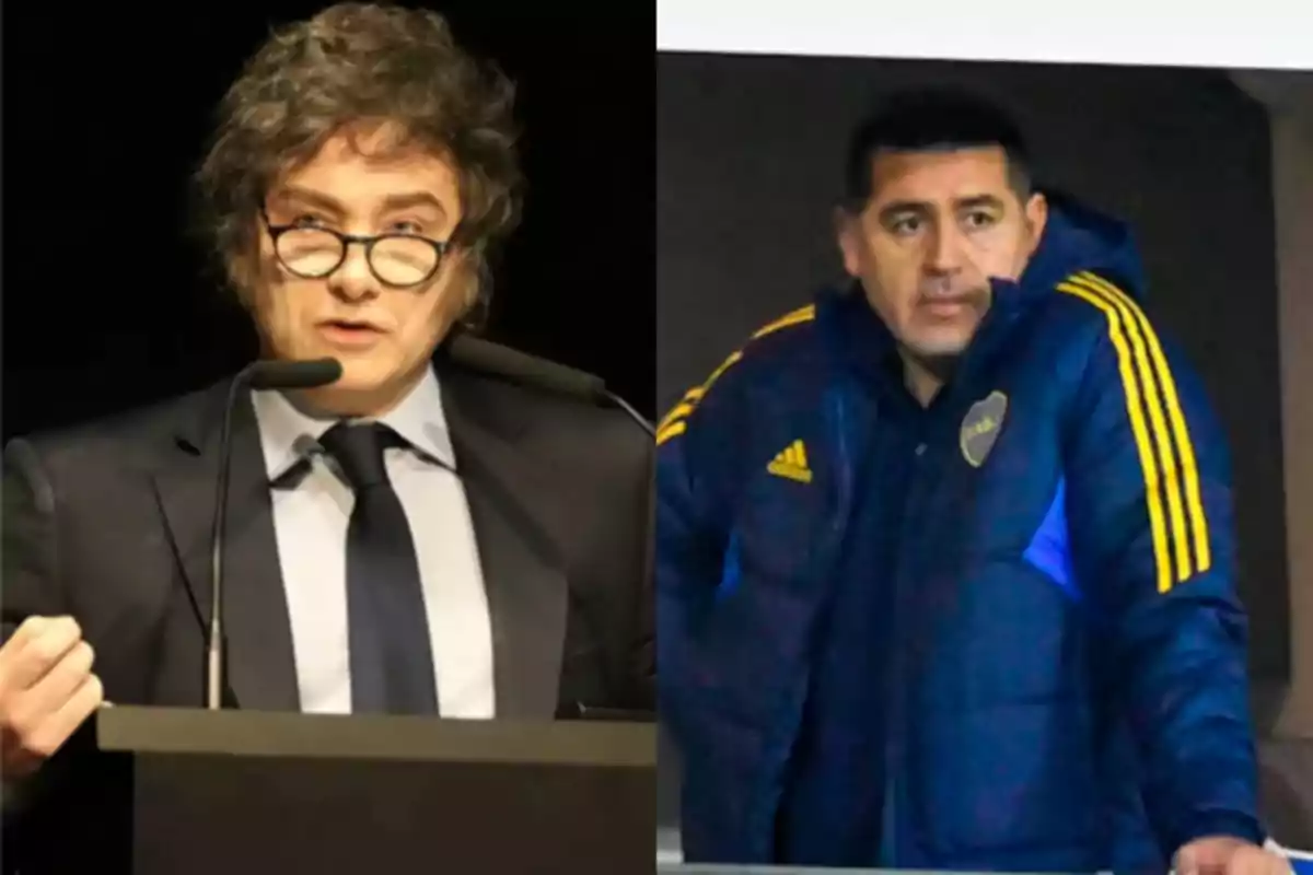 Two men, one wearing glasses and a suit speaking at a podium, and the other in a blue sports jacket with yellow details watching alertly.