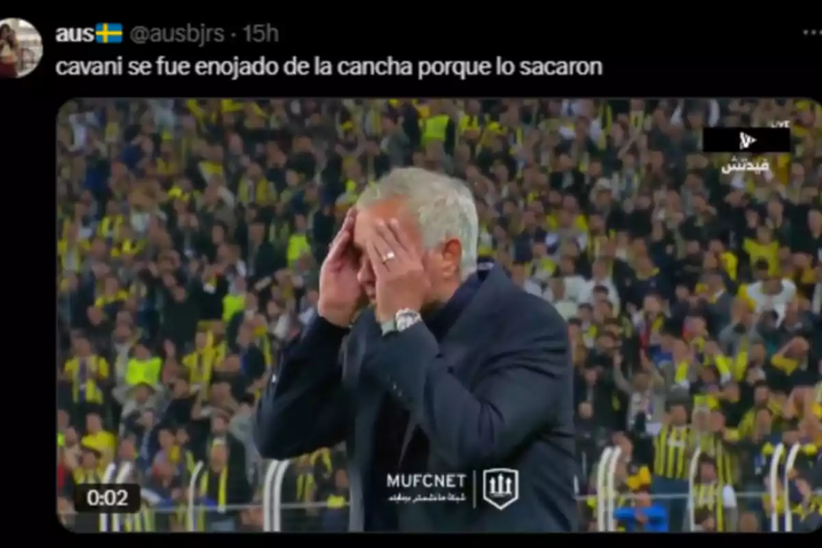 Gray-haired man in a dark suit covers his face with his hands in a stadium full of fans wearing yellow and black jerseys. Gray-haired man in a dark suit covers his face with his hands in a stadium full of fans wearing yellow and black jerseys.