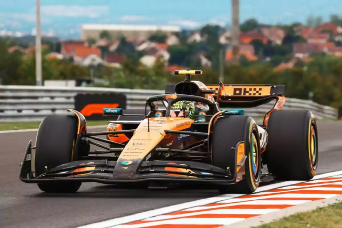 Orange and black Formula 1 single-seater driving on a track during a race Orange and black Formula 1 single-seater driving on a track during a race
