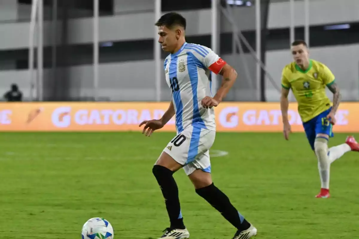 Argentinian player wearing number 10 controls the ball during a match against Brazil in a stadium. Argentinian player wearing number 10 controls the ball during a match against Brazil in a stadium.