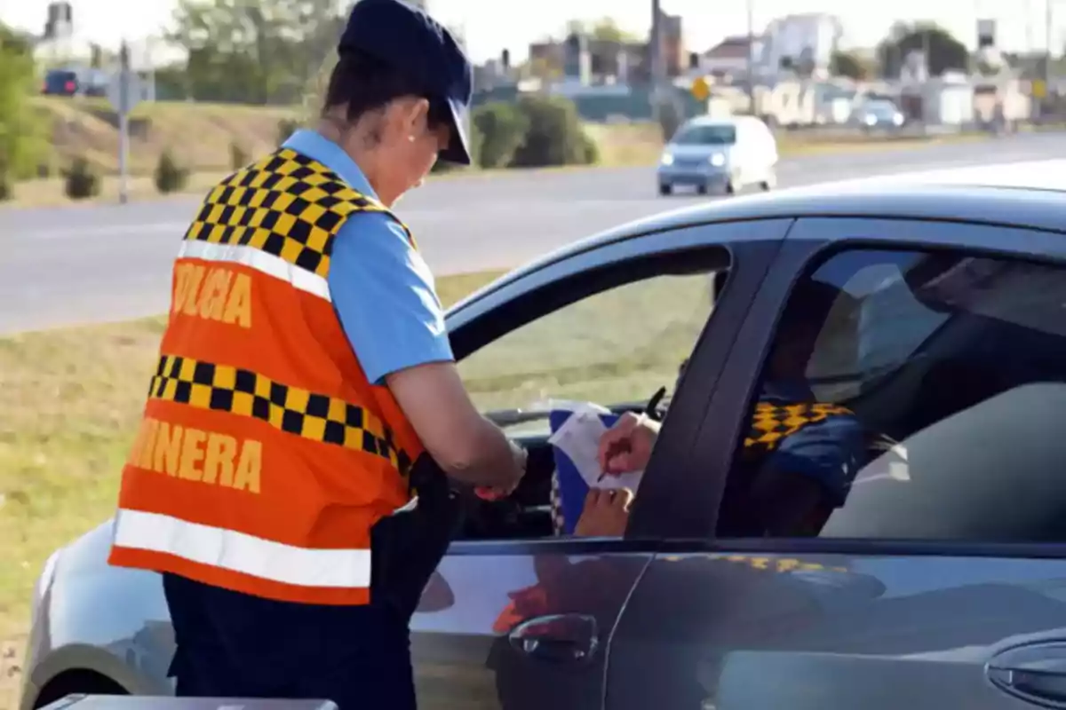 Traffic police officer stopping a car to check documents at a roadside checkpoint