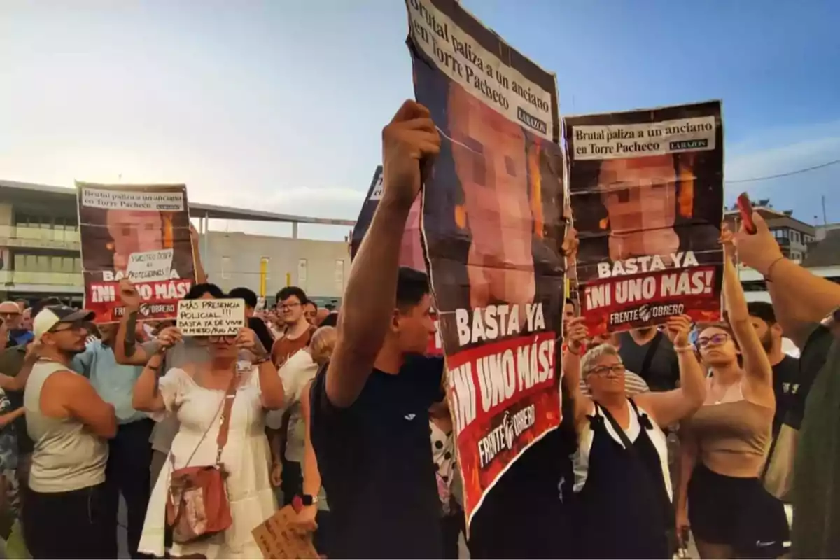 A group of people is protesting outdoors holding signs demanding greater safety and justice, some of which say A group of people is protesting outdoors holding signs demanding greater safety and justice, some of which say