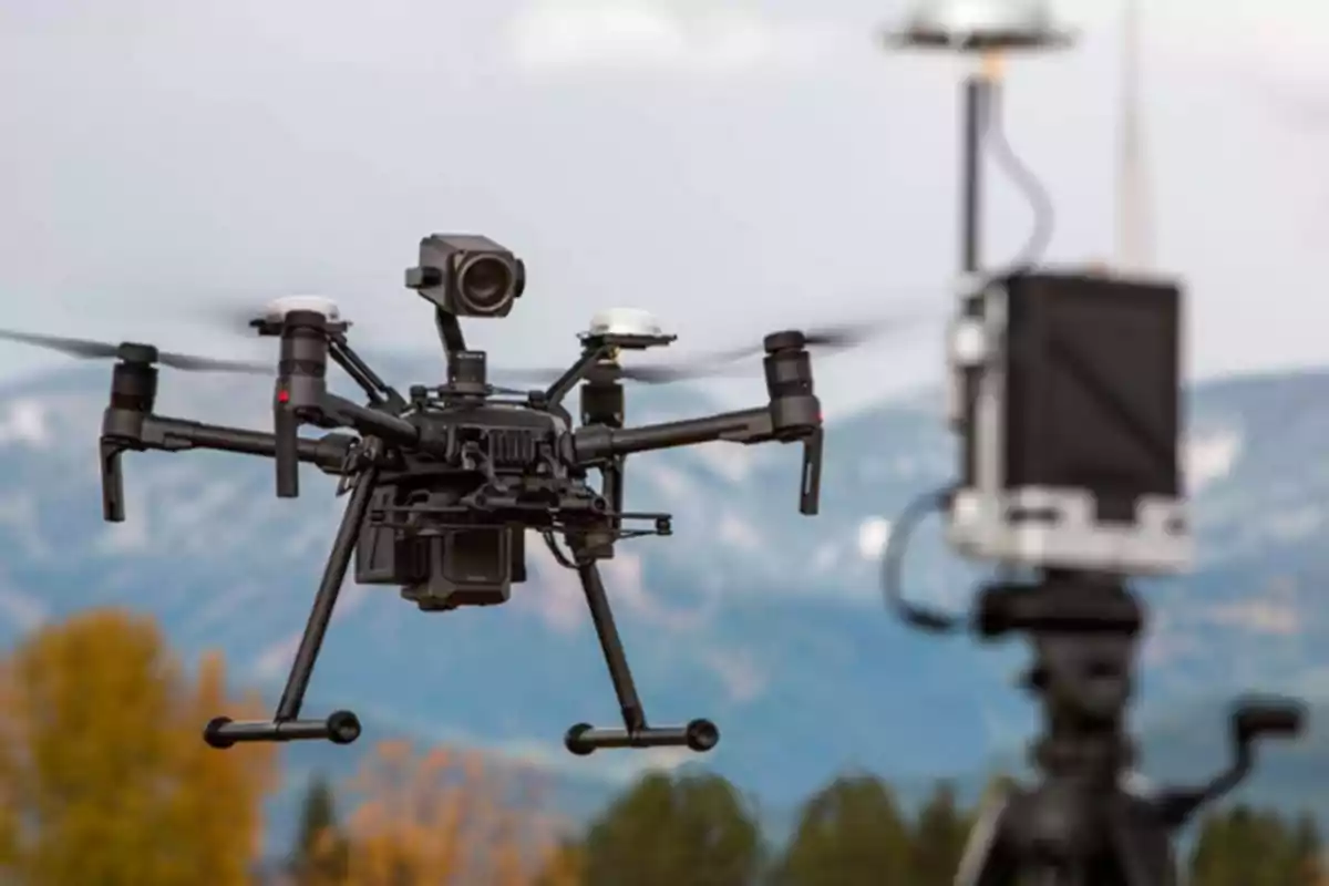 A professional drone flies outdoors with a background of mountains and trees, while a control station is in the foreground. A professional drone flies outdoors with a background of mountains and trees, while a control station is in the foreground.