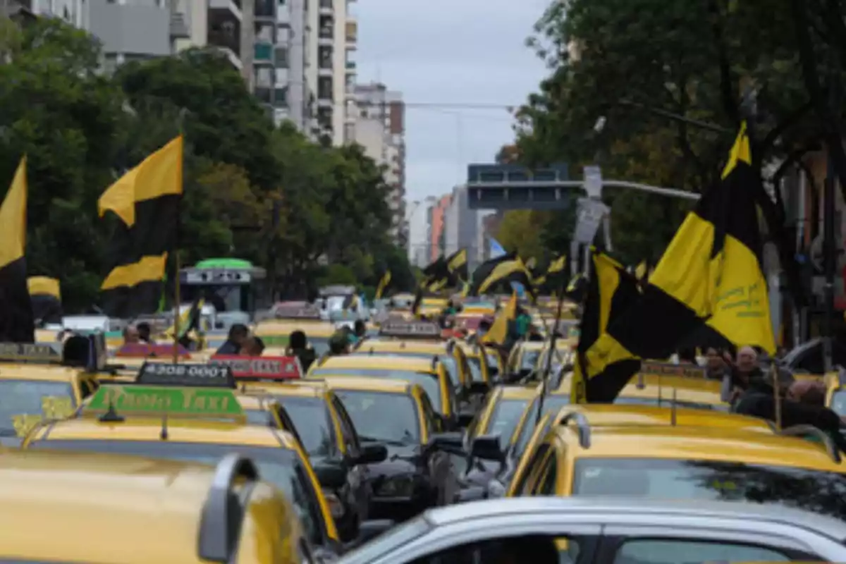 Yellow taxis with black and yellow flags occupy an avenue in the middle of a protest in the city.
