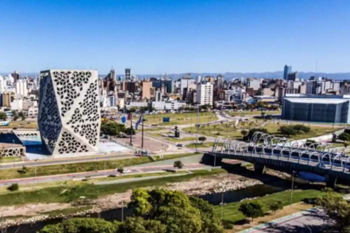 Vista panorámica de la ciudad de Córdoba con el edificio del Centro Cívico y un puente moderno sobre un arroyo en primer plano