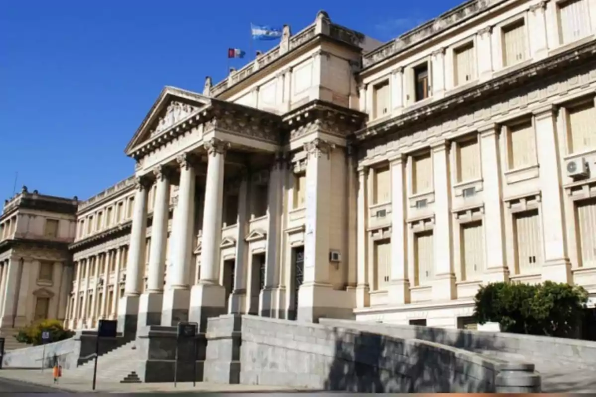 Facade of a historic neoclassical building with columns and staircases under a clear sky Facade of a historic neoclassical building with columns and staircases under a clear sky
