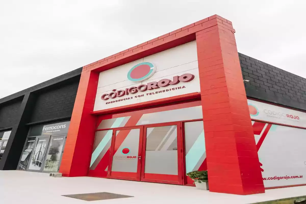 Facade of a modern building with red and white details that belongs to an emergency clinic called Código Rojo