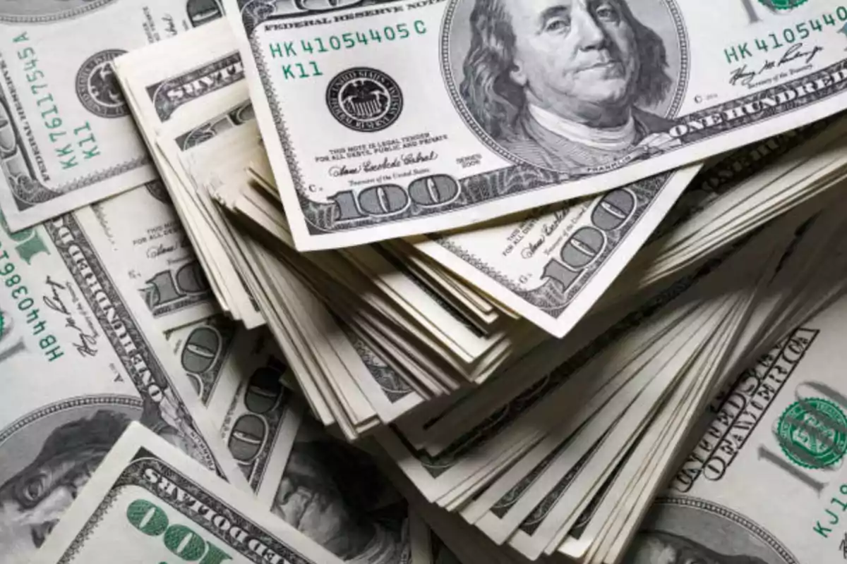 Several one-hundred-dollar bills stacked in piles Several one-hundred-dollar bills stacked in piles