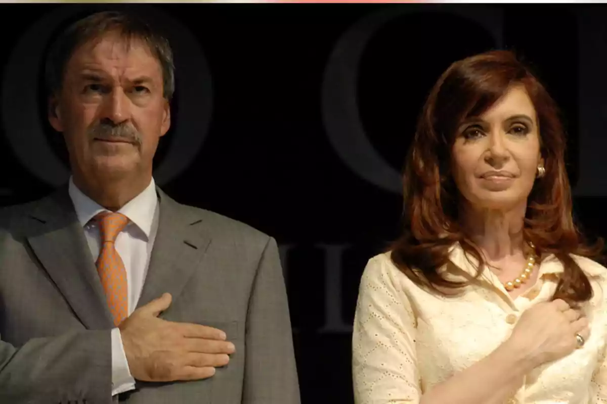 Dos personas de pie con la mano en el pecho en actitud solemne Dos personas de pie con la mano en el pecho en actitud solemne