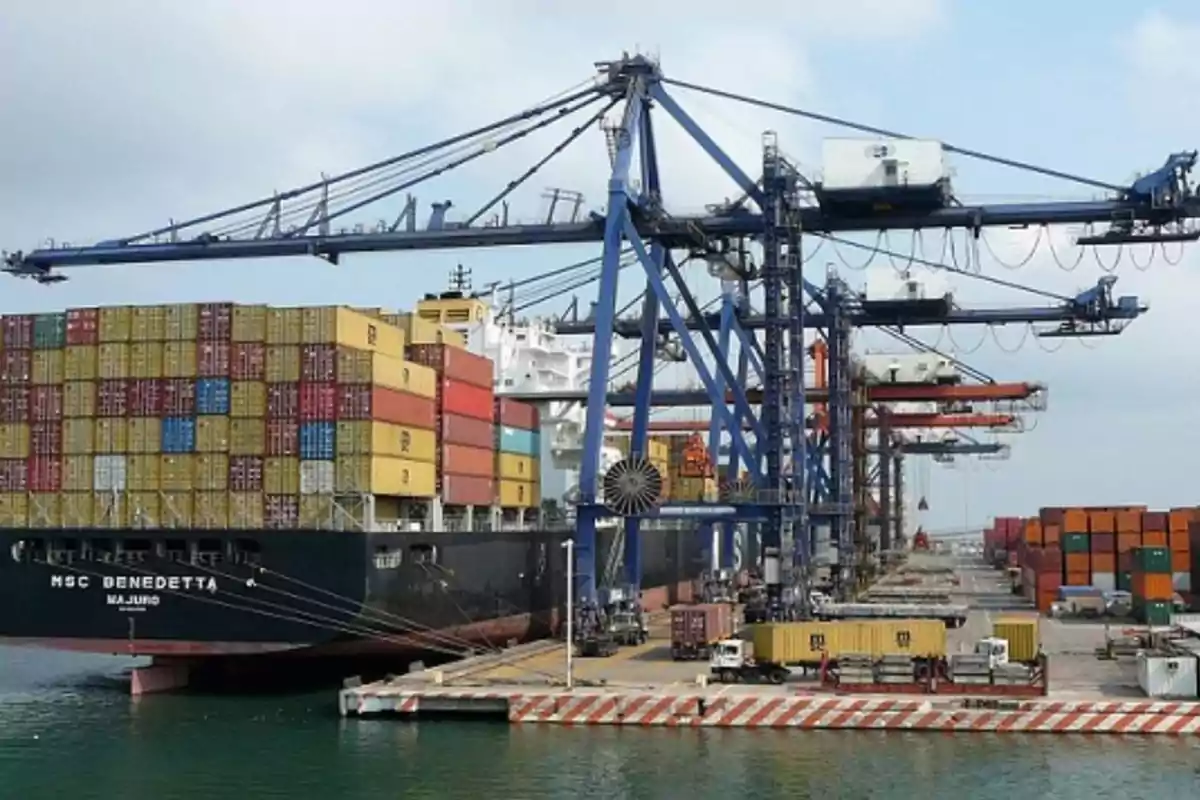 A container ship is docked at a port while several cranes unload and load colorful containers. A container ship is docked at a port while several cranes unload and load colorful containers.