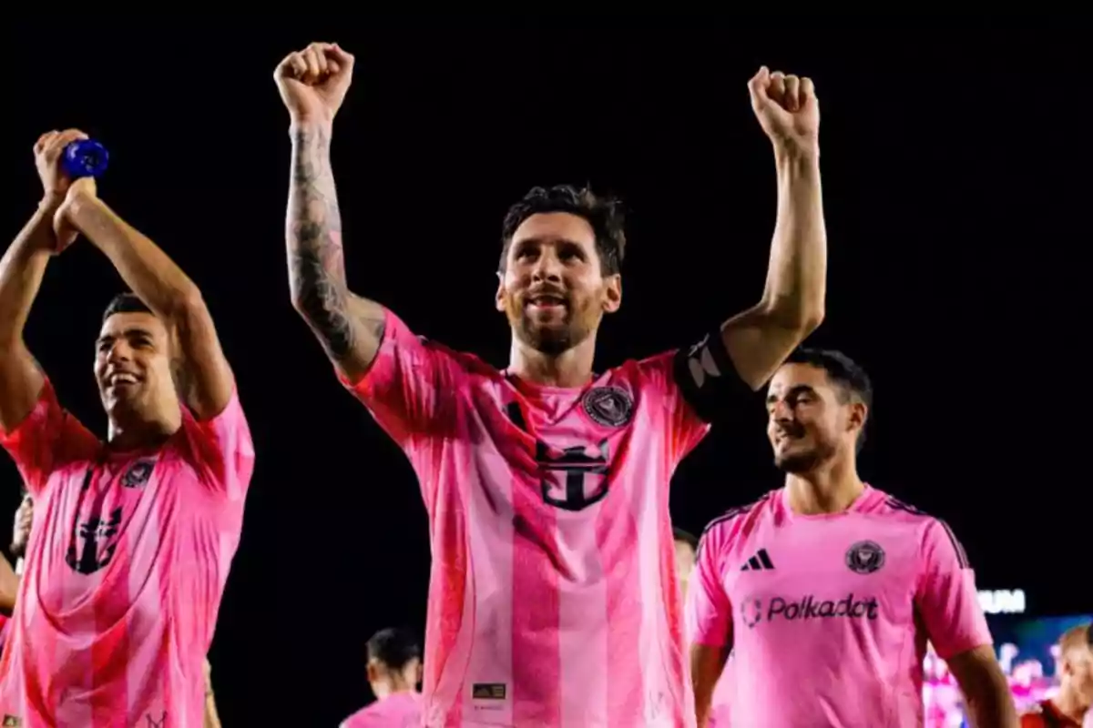 Jugadores del Inter Miami celebran una victoria con los brazos en alto y sonriendo, vistiendo uniformes rosas Jugadores del Inter Miami celebran una victoria con los brazos en alto y sonriendo, vistiendo uniformes rosas