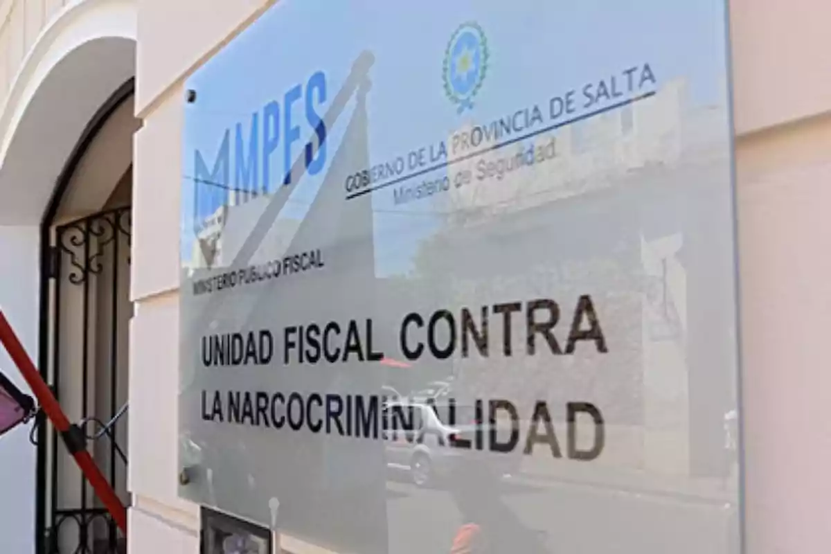 Sign of the Narcocriminality Prosecutor’s Unit in the province of Salta reflected on a glass panel at the entrance of an official building