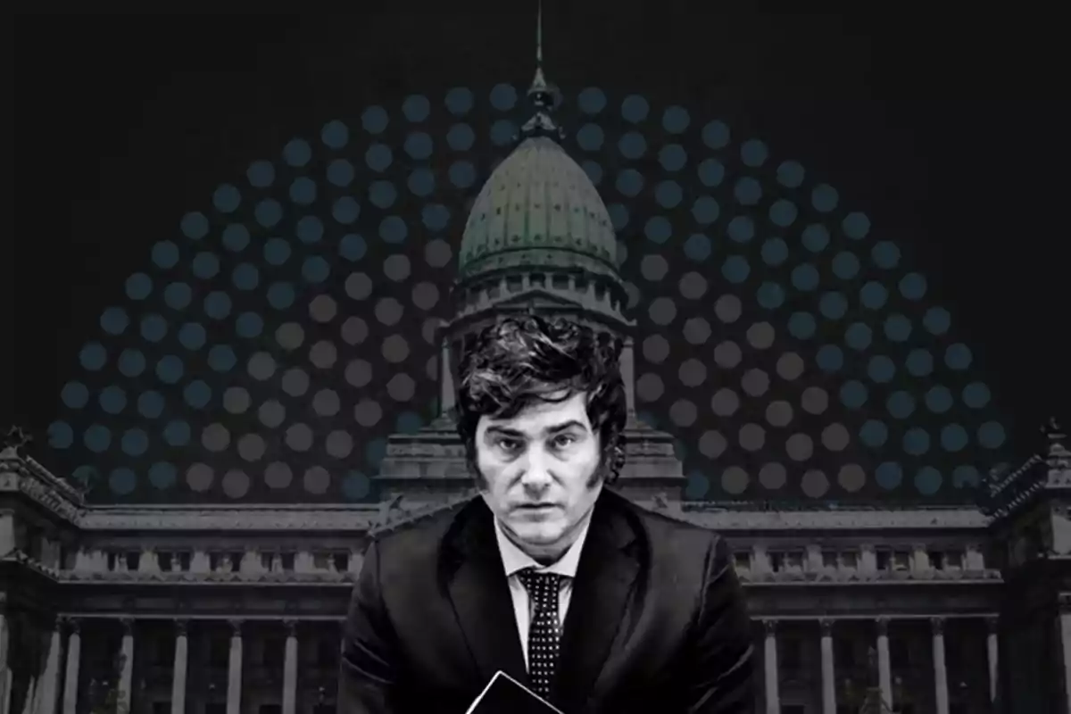 Dark-haired man in a formal suit in front of a government building with a dome and a background of blue dots on black