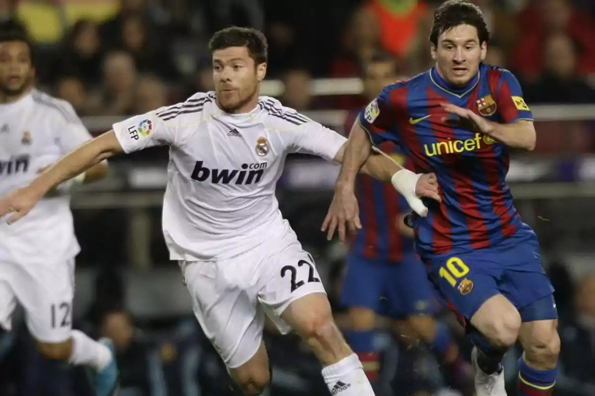 Two players from the teams Real Madrid and Barcelona compete for the ball during a match. Two players from the teams Real Madrid and Barcelona compete for the ball during a match.