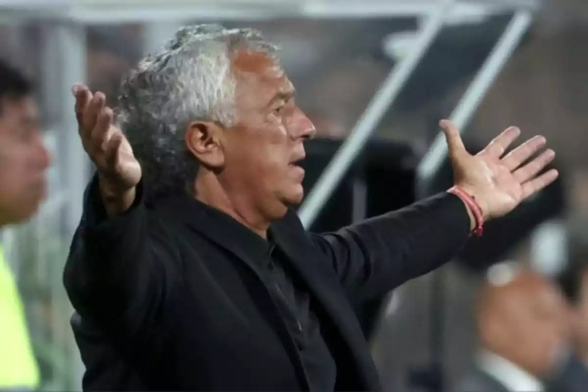 Gray-haired man with a look of surprise or frustration and arms outstretched during a sporting event Gray-haired man with a look of surprise or frustration and arms outstretched during a sporting event