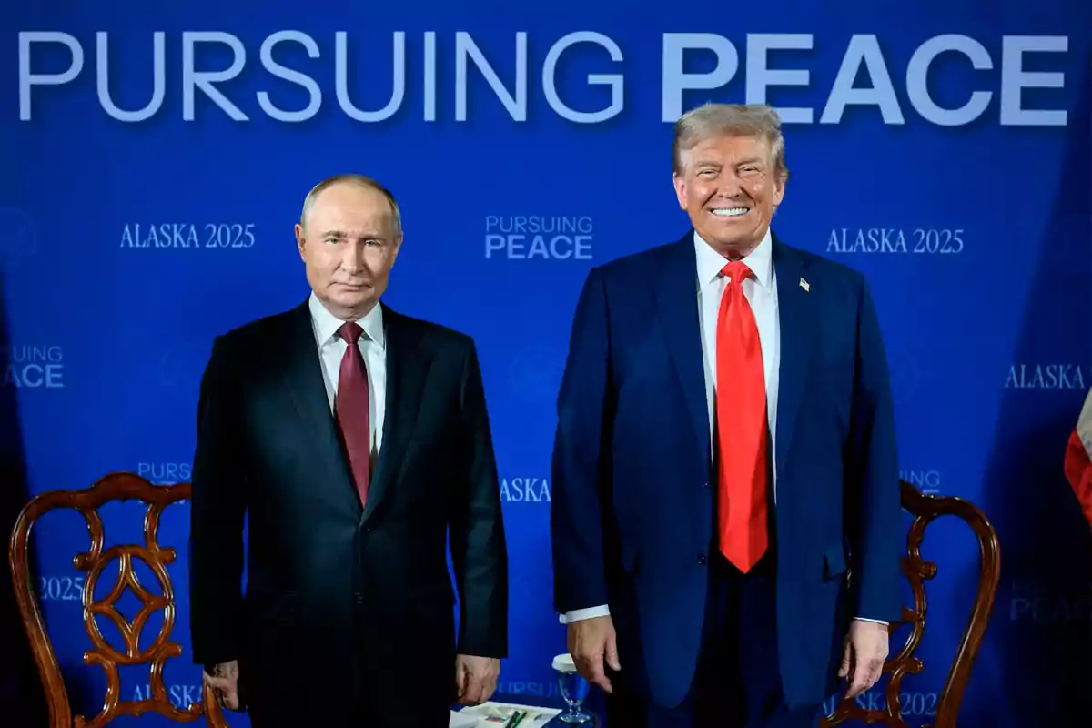 Dos hombres de traje posan frente a un fondo azul con el texto Pursuing Peace y Alaska 2025