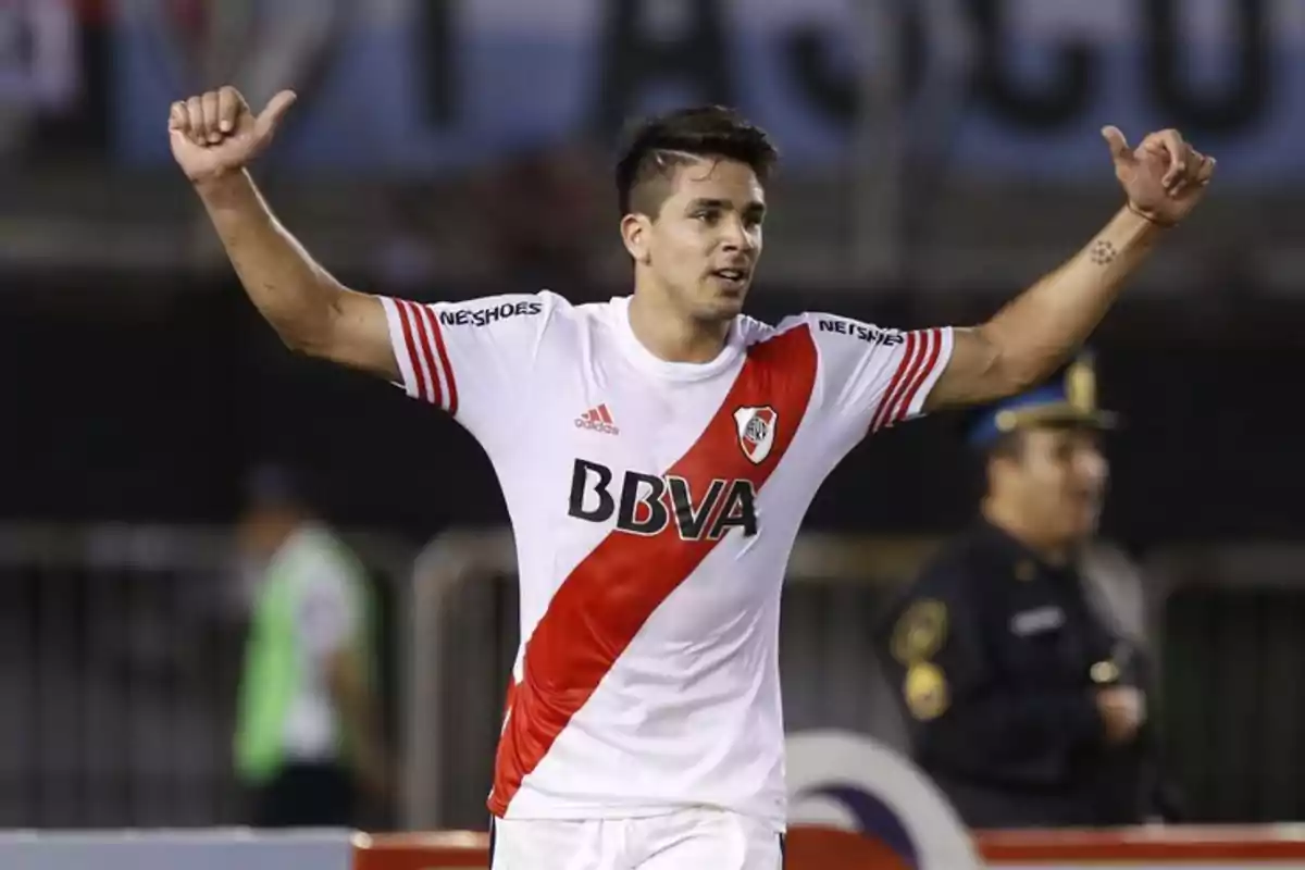 Futbolista con uniforme de River Plate celebrando con los brazos en alto en un estadio Futbolista con uniforme de River Plate celebrando con los brazos en alto en un estadio