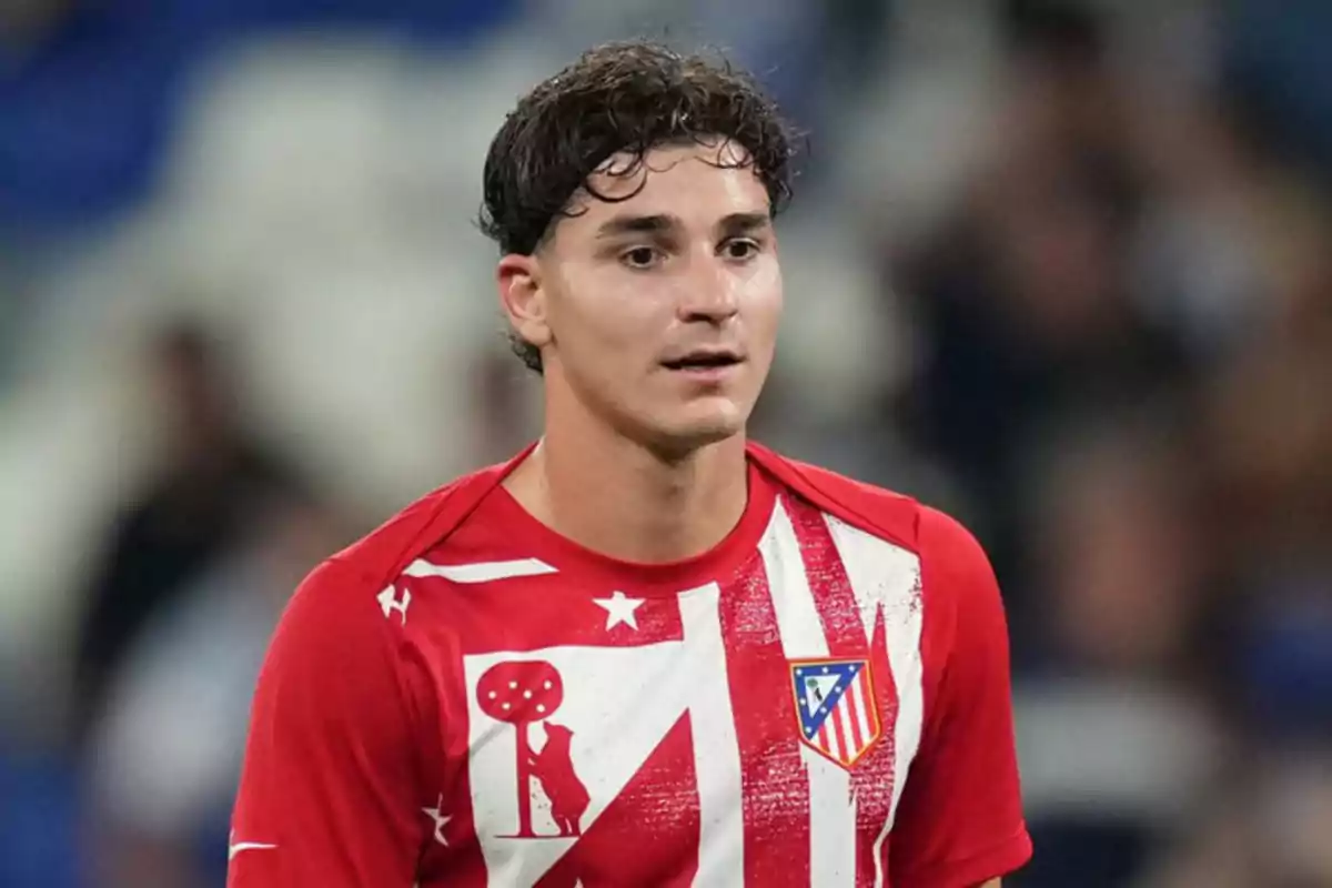 Jugador de fútbol con camiseta roja y blanca del Atlético de Madrid durante un partido
