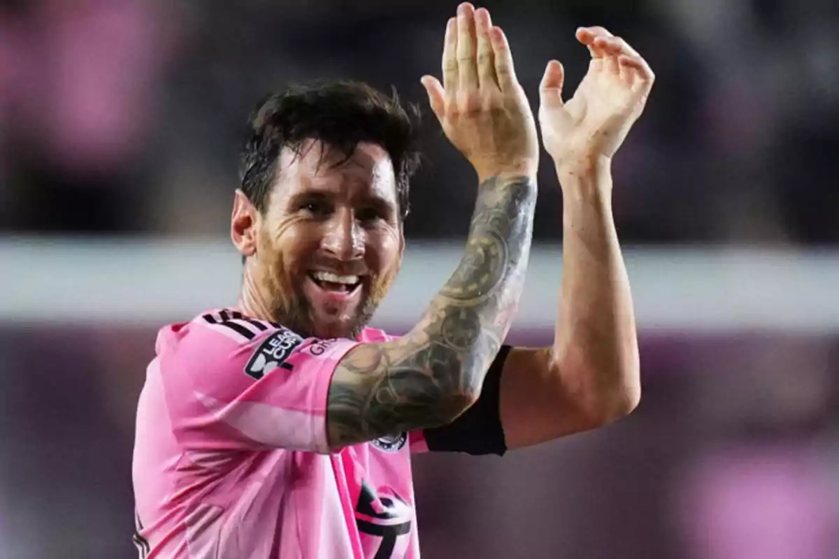 Futbolista con uniforme rosa aplaudiendo y sonriendo durante un partido Futbolista con uniforme rosa aplaudiendo y sonriendo durante un partido