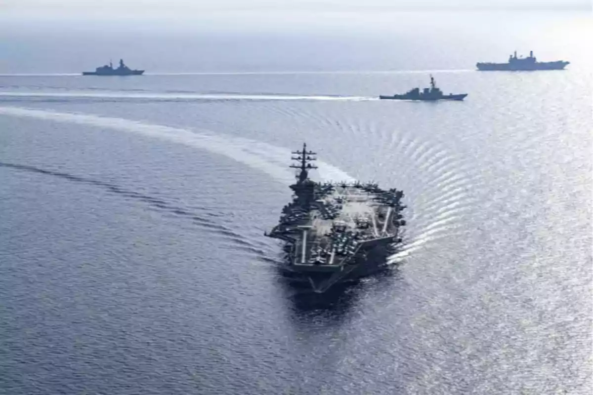 Portaaviones navegando en el mar escoltado por varios buques de guerra Portaaviones navegando en el mar escoltado por varios buques de guerra