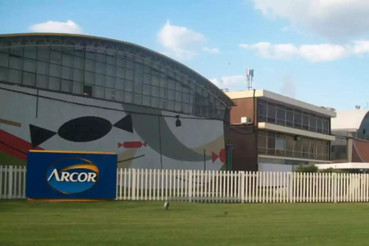 Arcor factory with a blue sign on the lawn and a candy mural on the building’s wall