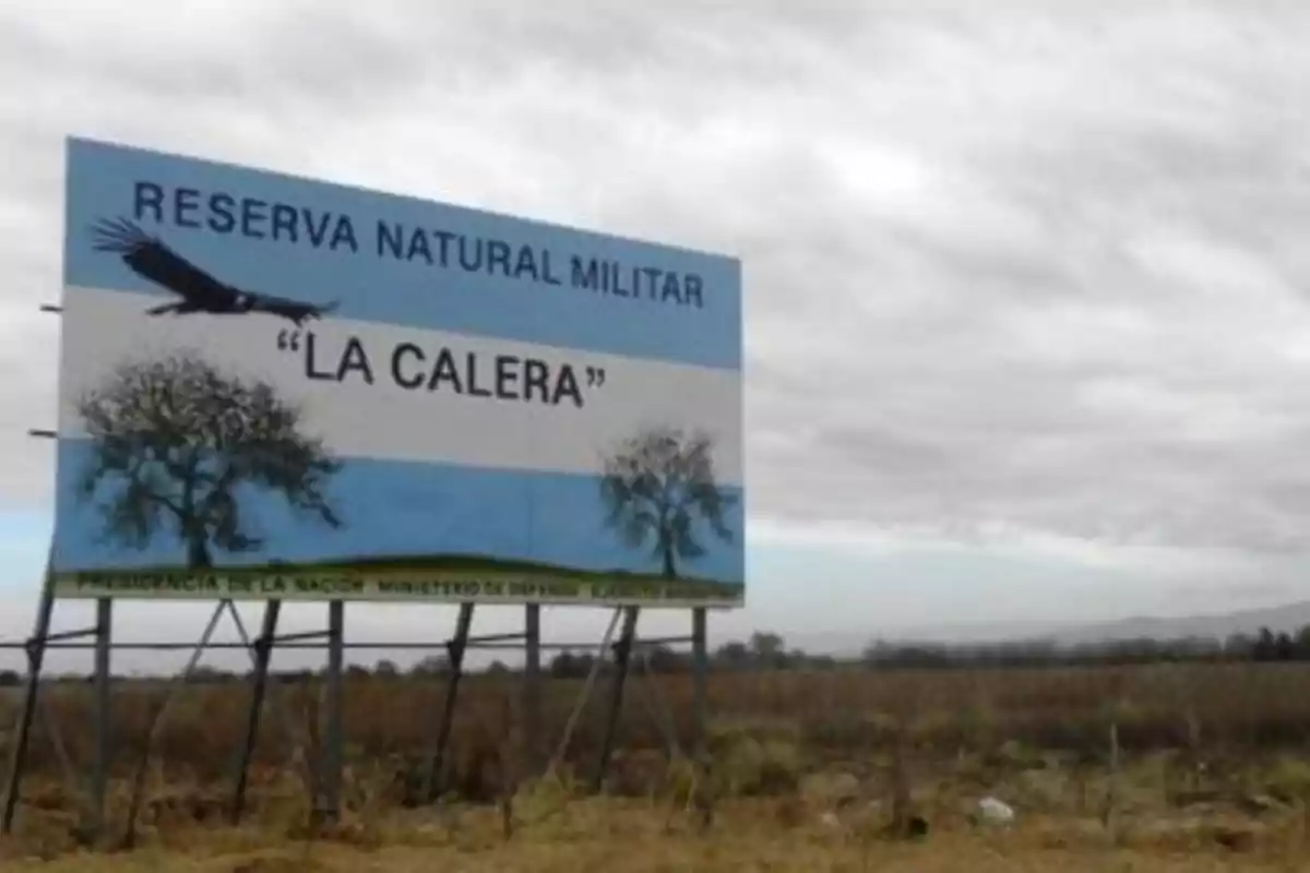 Cartel grande en un campo que indica la entrada a la Reserva Natural Militar La Calera con un fondo de cielo nublado y paisaje rural Cartel grande en un campo que indica la entrada a la Reserva Natural Militar La Calera con un fondo de cielo nublado y paisaje rural